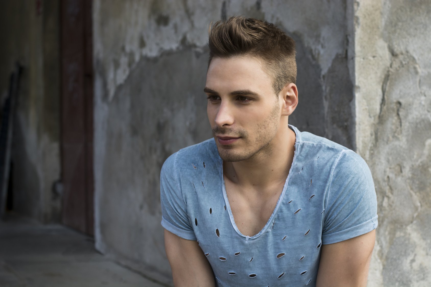 Young man outdoor in front of concrete wall