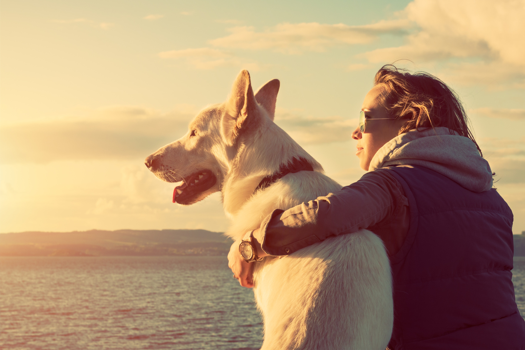 Young attractive girl with her pet dog at a beach, colorised image