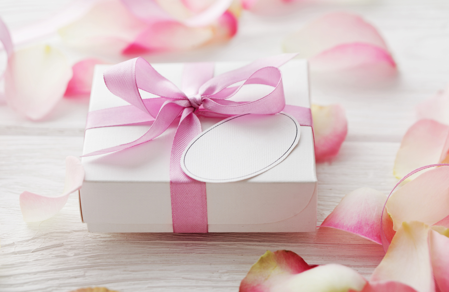gift box with blank gift tag and flower petals