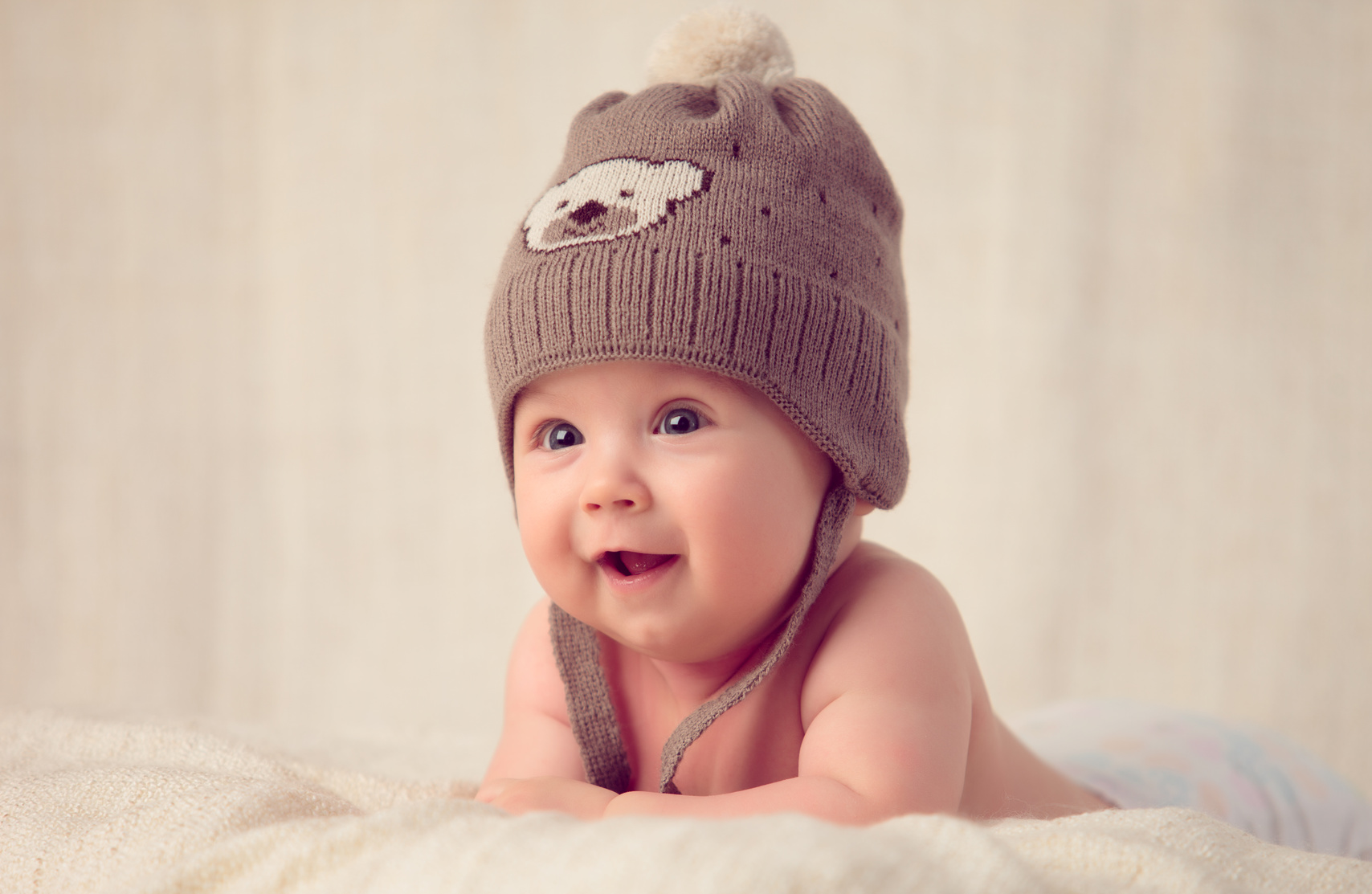 Baby lying on a soft bed cover