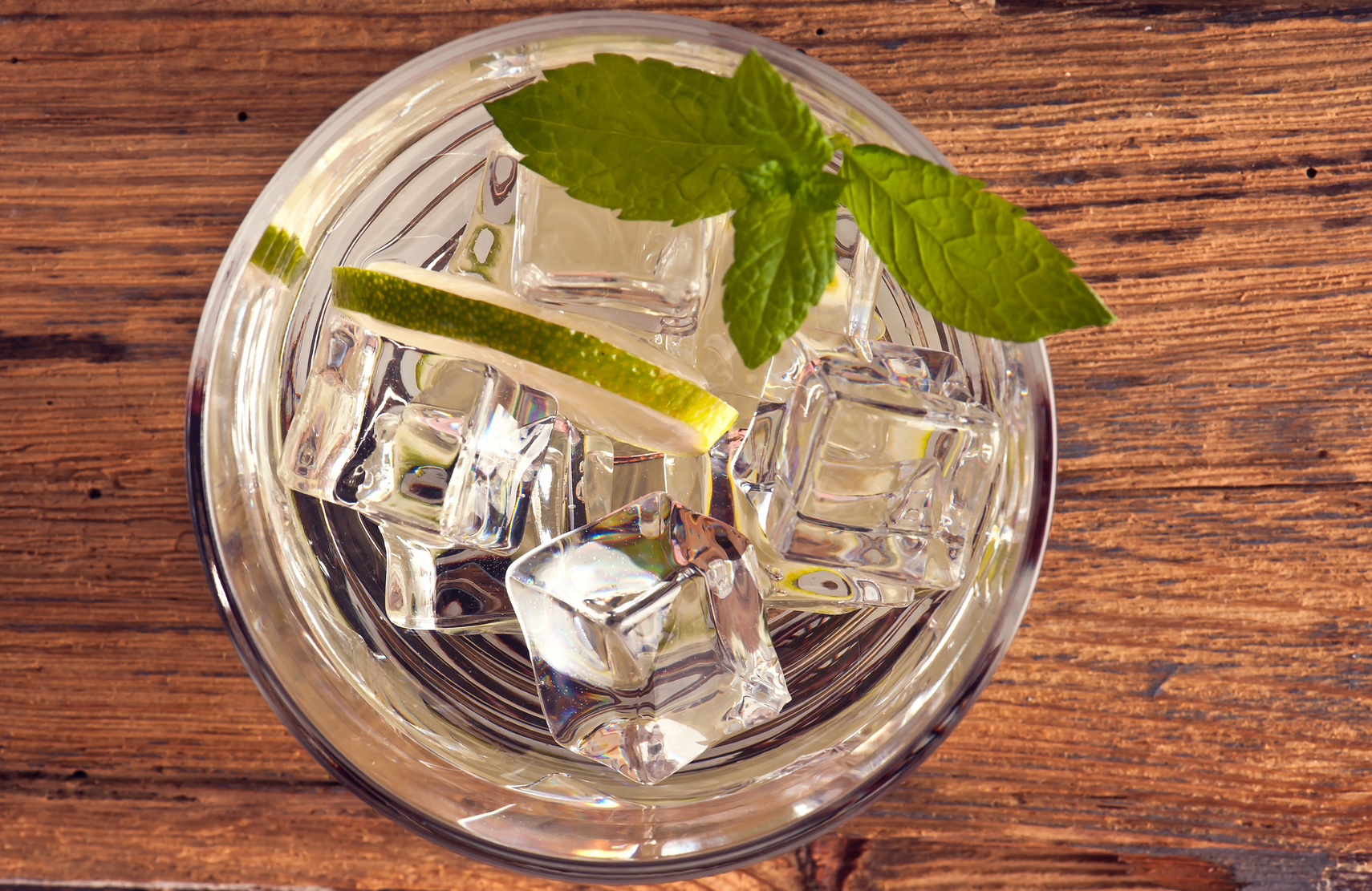 alcoholic drink with lemon and ice on a old wooden table