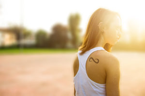 Beauty Romantic Girl Outdoors. Beautiful Teenage Model girl Dressed in Casual Short Dress outdoor in Sun Light. summer. Glow Sun, Sunshine.Toned in warm colors tattoo
