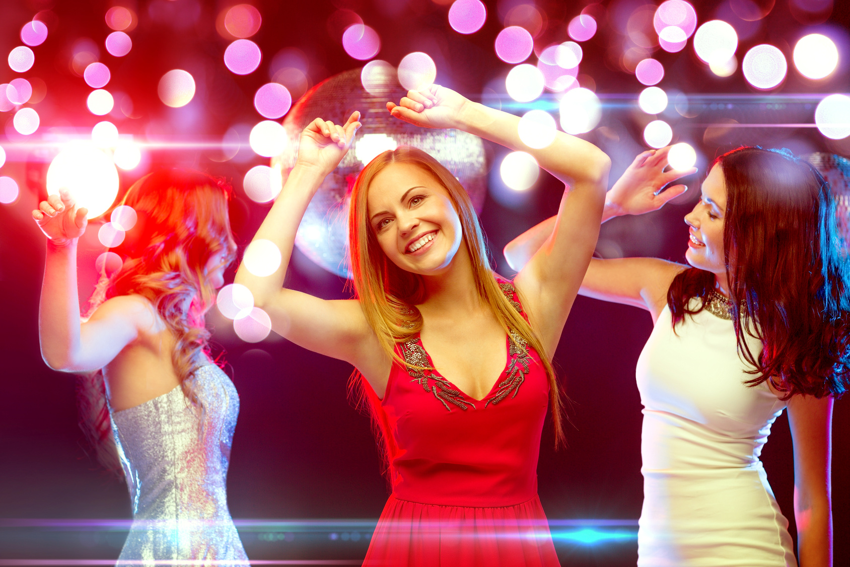 three smiling women dancing in the club