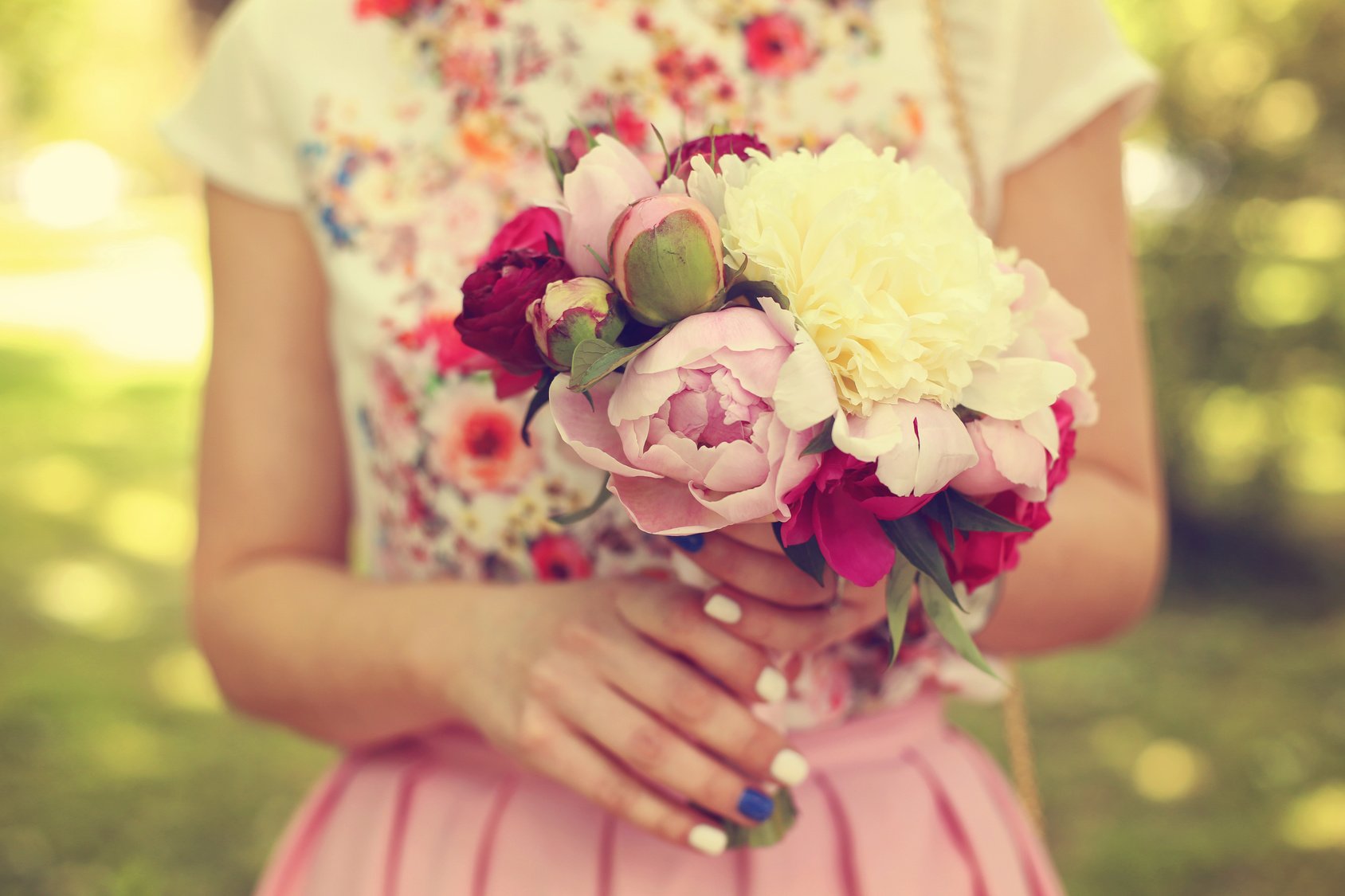 Hands of a woman holding beautiful peonies bouquet