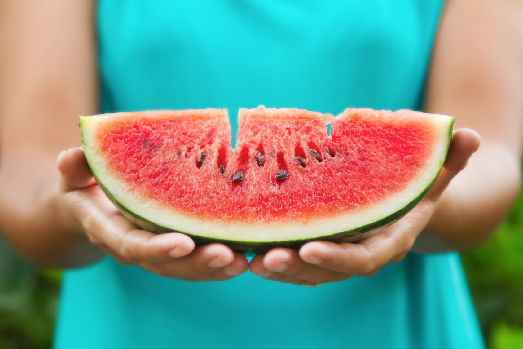 watermelon slice on hands