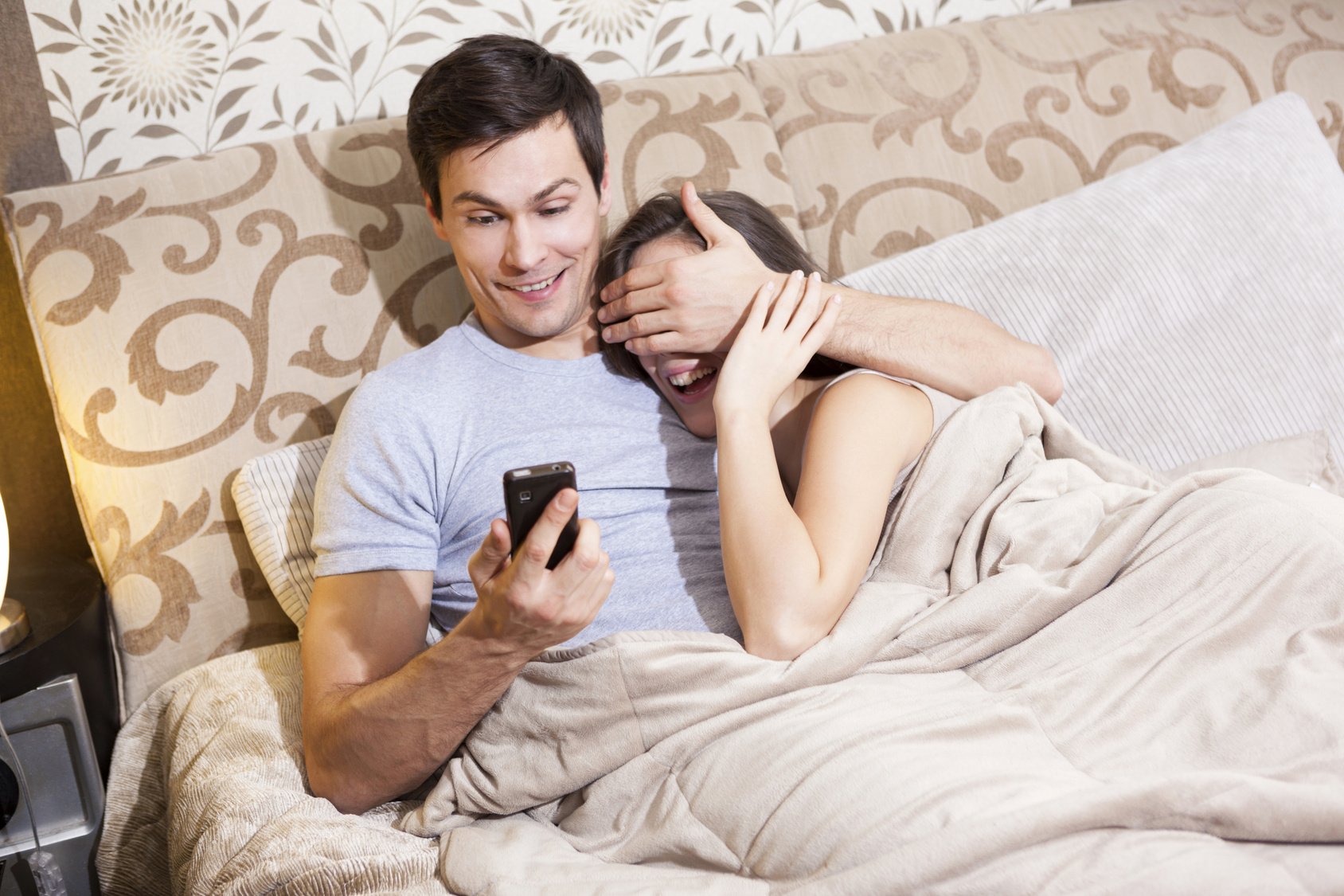 Young man hiding content of the text message from his girlfriend