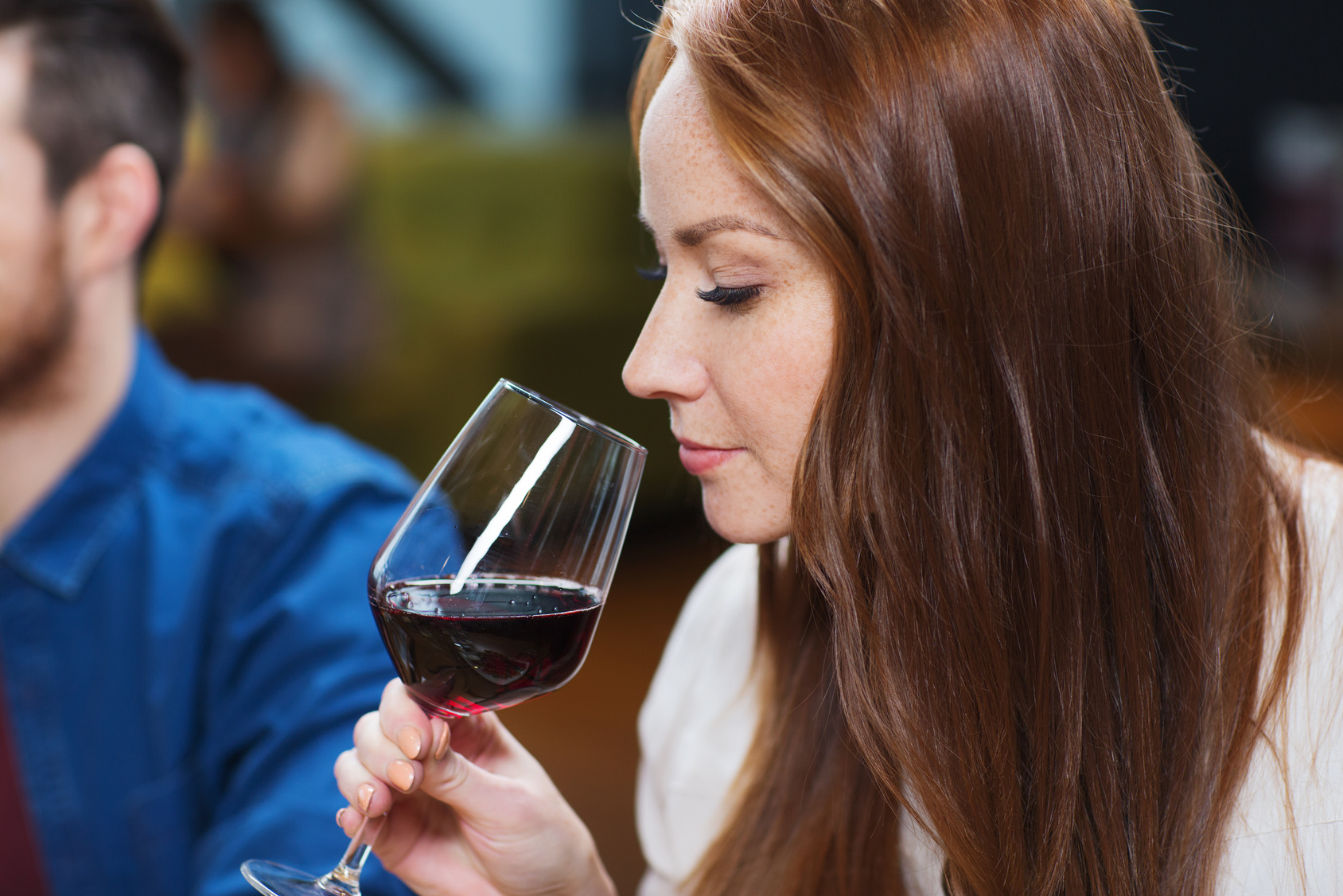 smiling woman drinking red wine at restaurant