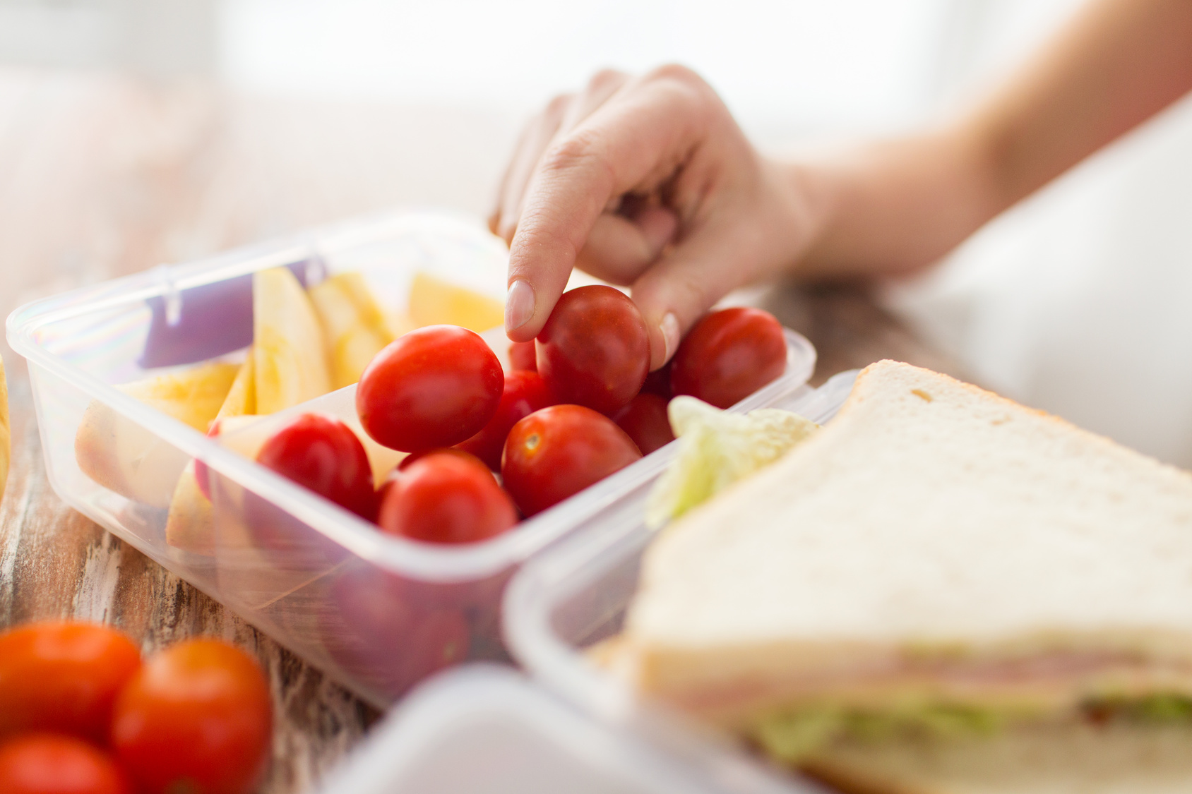 close up of woman with food in plastic container