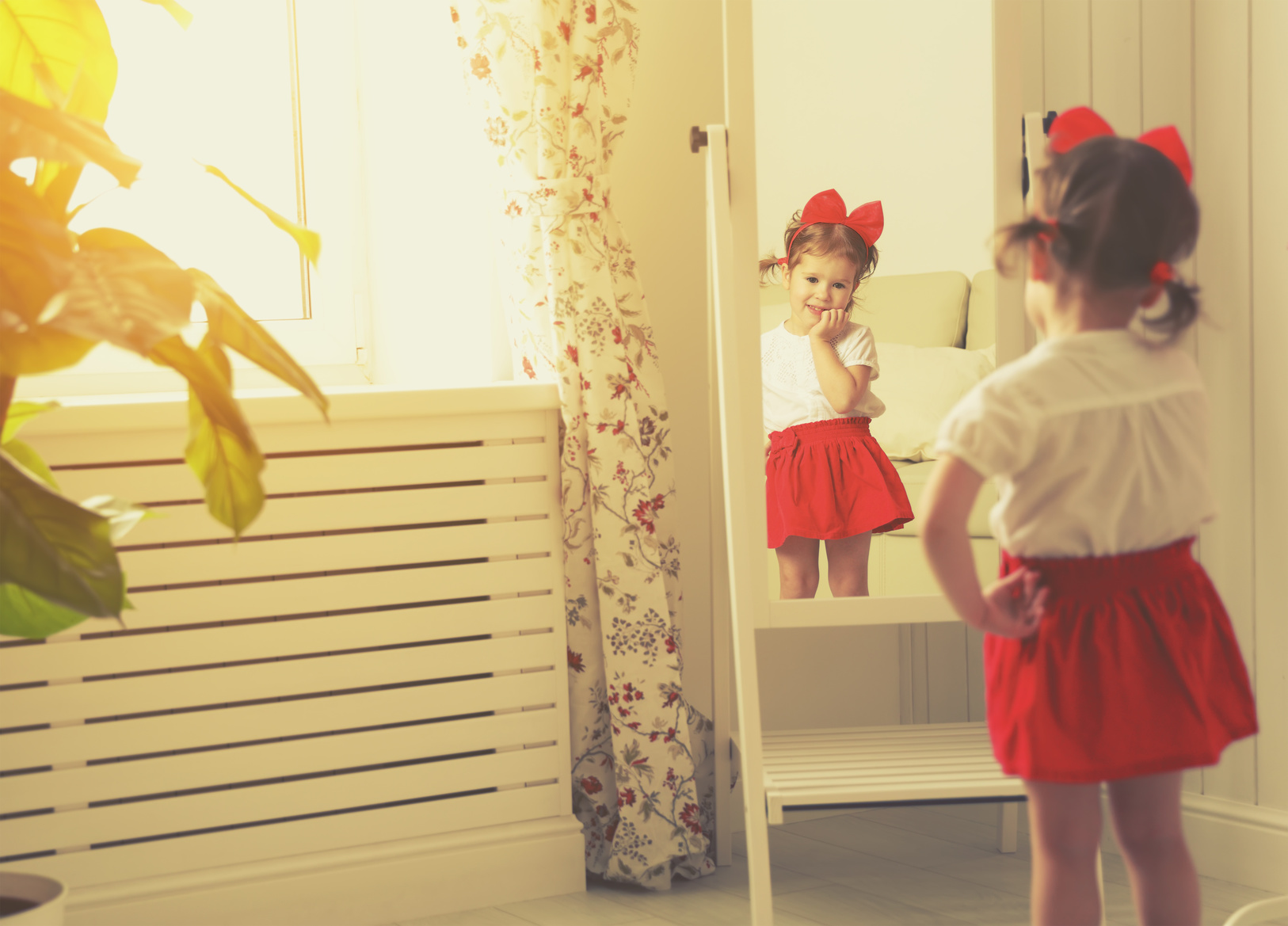 little girl child fashionista looking in the mirror at home