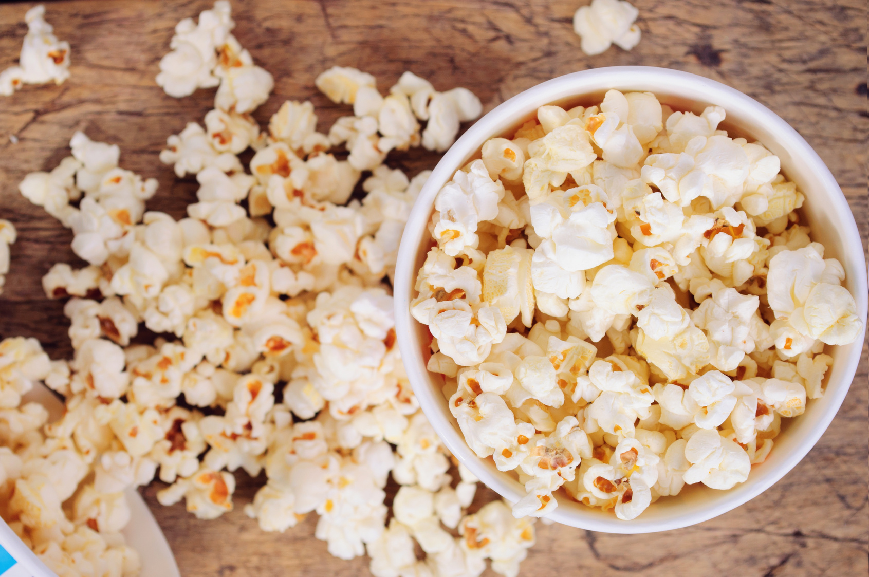 Popcorn in paper cups on wooden surface. Top view