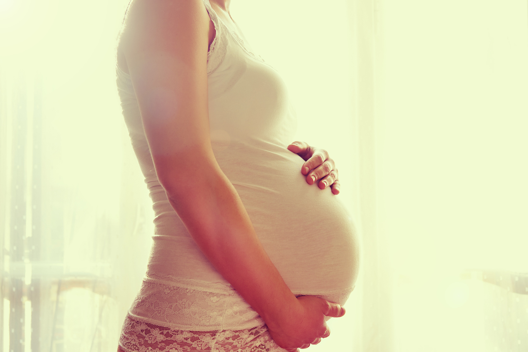 Image of pregnant woman touching her belly with hands