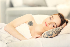 Attractive woman with tattoo lying on the bed