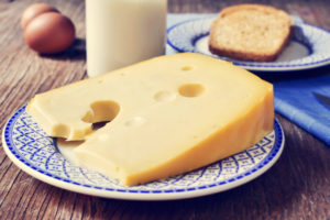 cheese, milk, eggs and bread on a rustic wooden table, with a filter effect