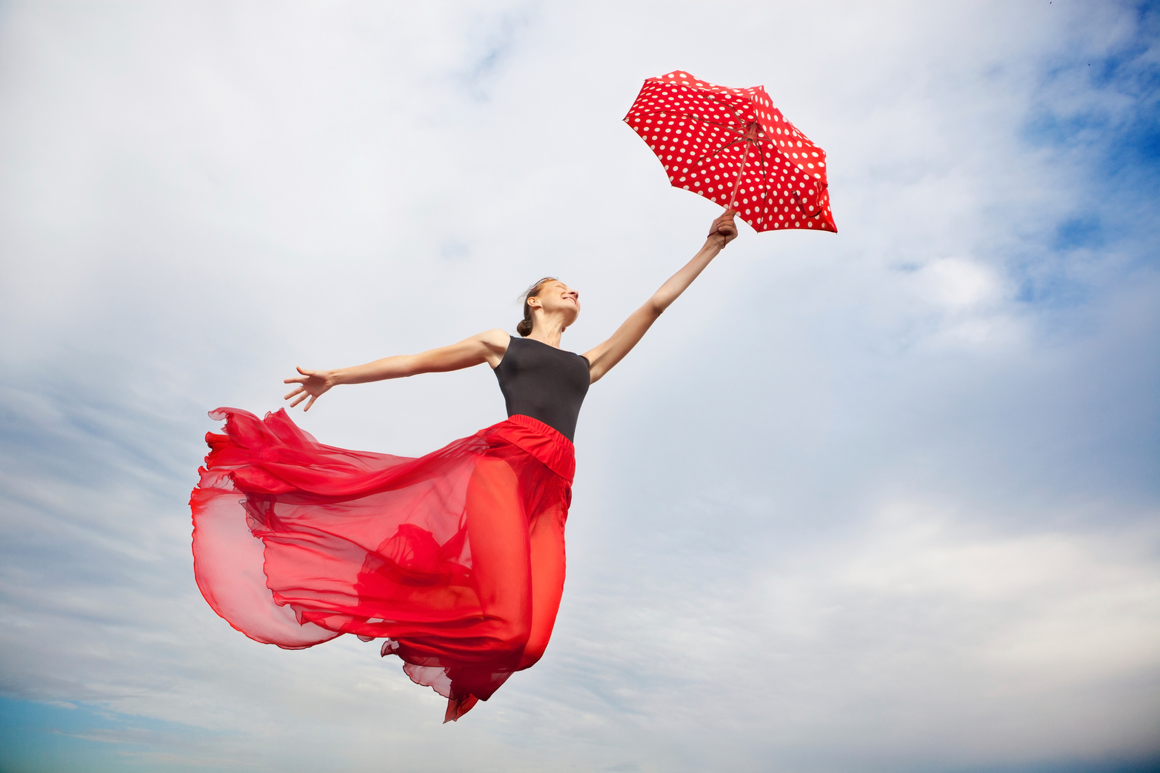 Young Woman Flying in the Sky with Umbrella