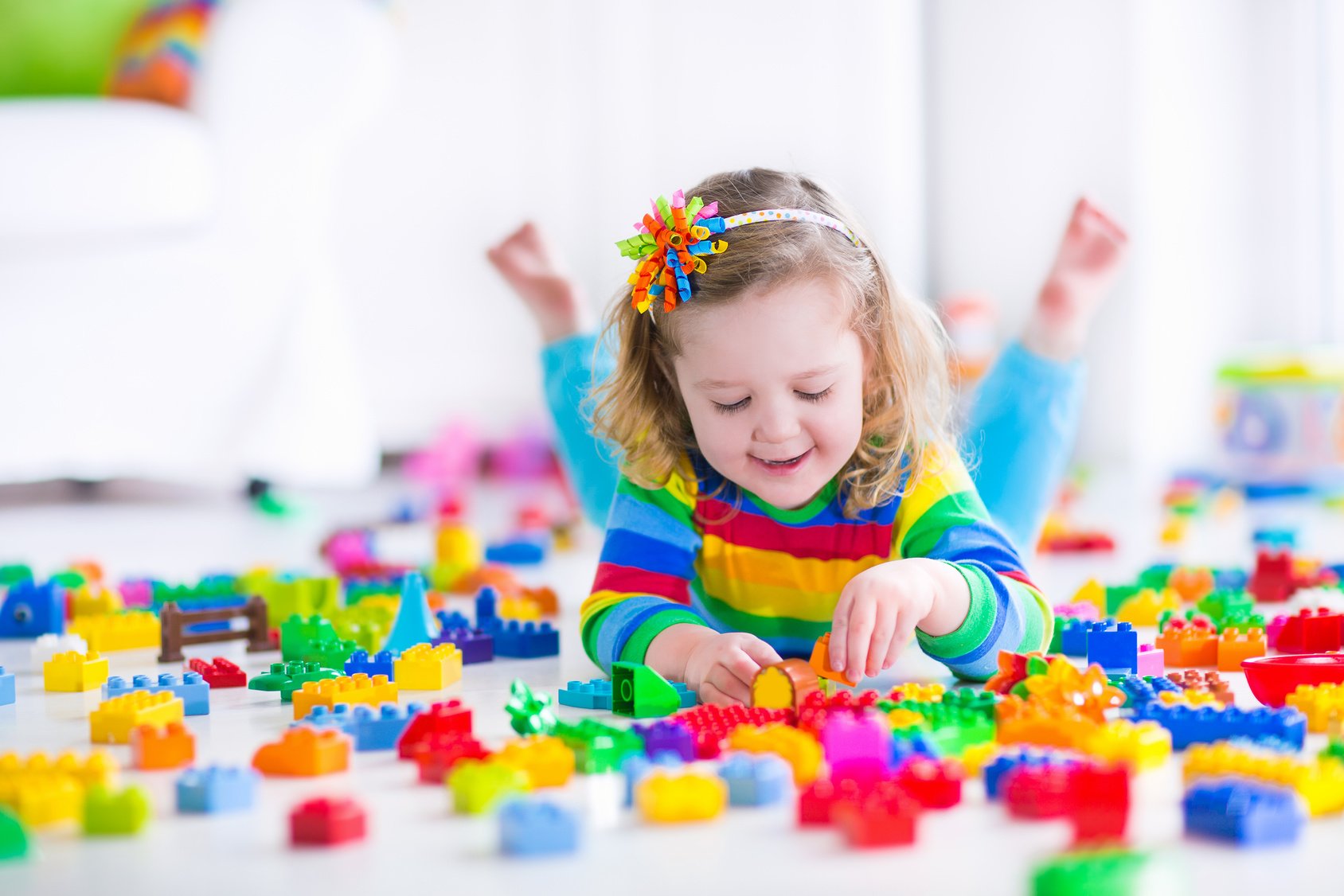 Little girl playing with toy blocks room child