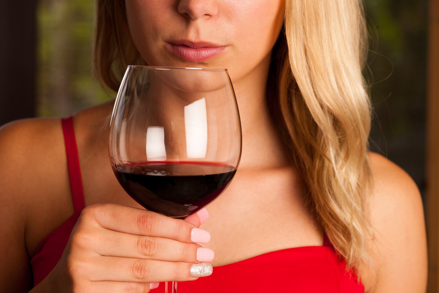 Beautiful woman drinks red wine outdoor on a hot summer afternoo