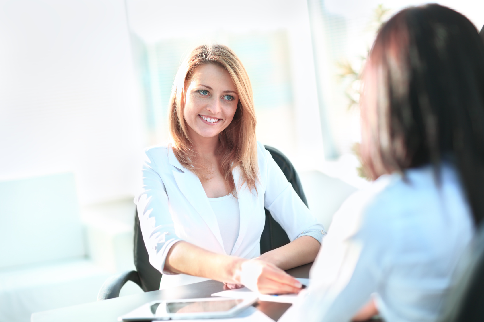 Two Businesswomen Having Informal Meeting In Modern Office