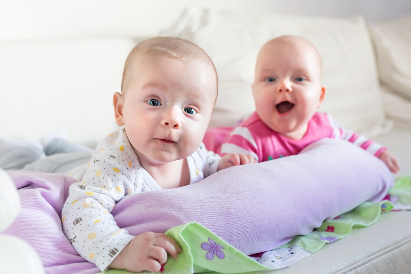 Baby twins lie on his tummy