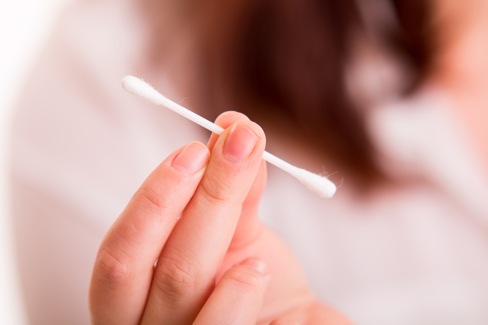 Cotton buds in woman’s hand