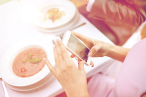 close up of couple with smartphones at restaurant