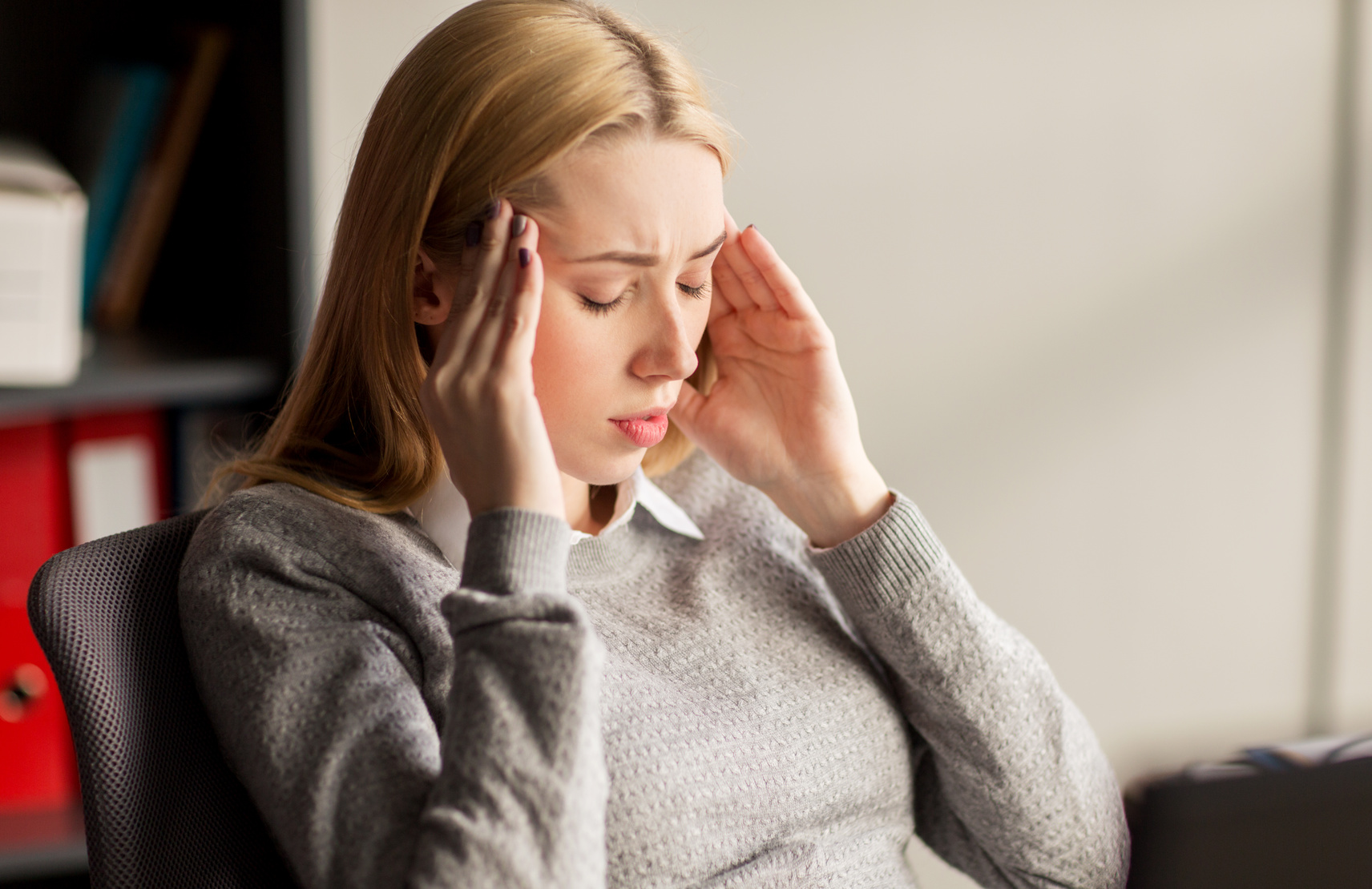 close up of businesswoman with headache at office