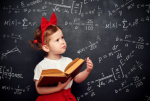 wunderkind little girl schoolgirl with a book from the blackboard with physical formulas