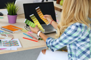 Hands of female designer in office working with colour samples