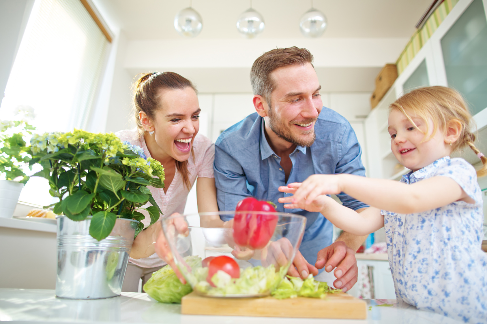 Kind in der Familie hilft beim Salat machen