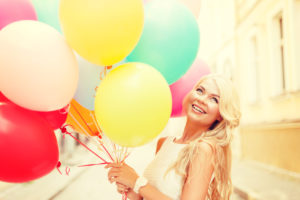 smiling woman with colorful balloons