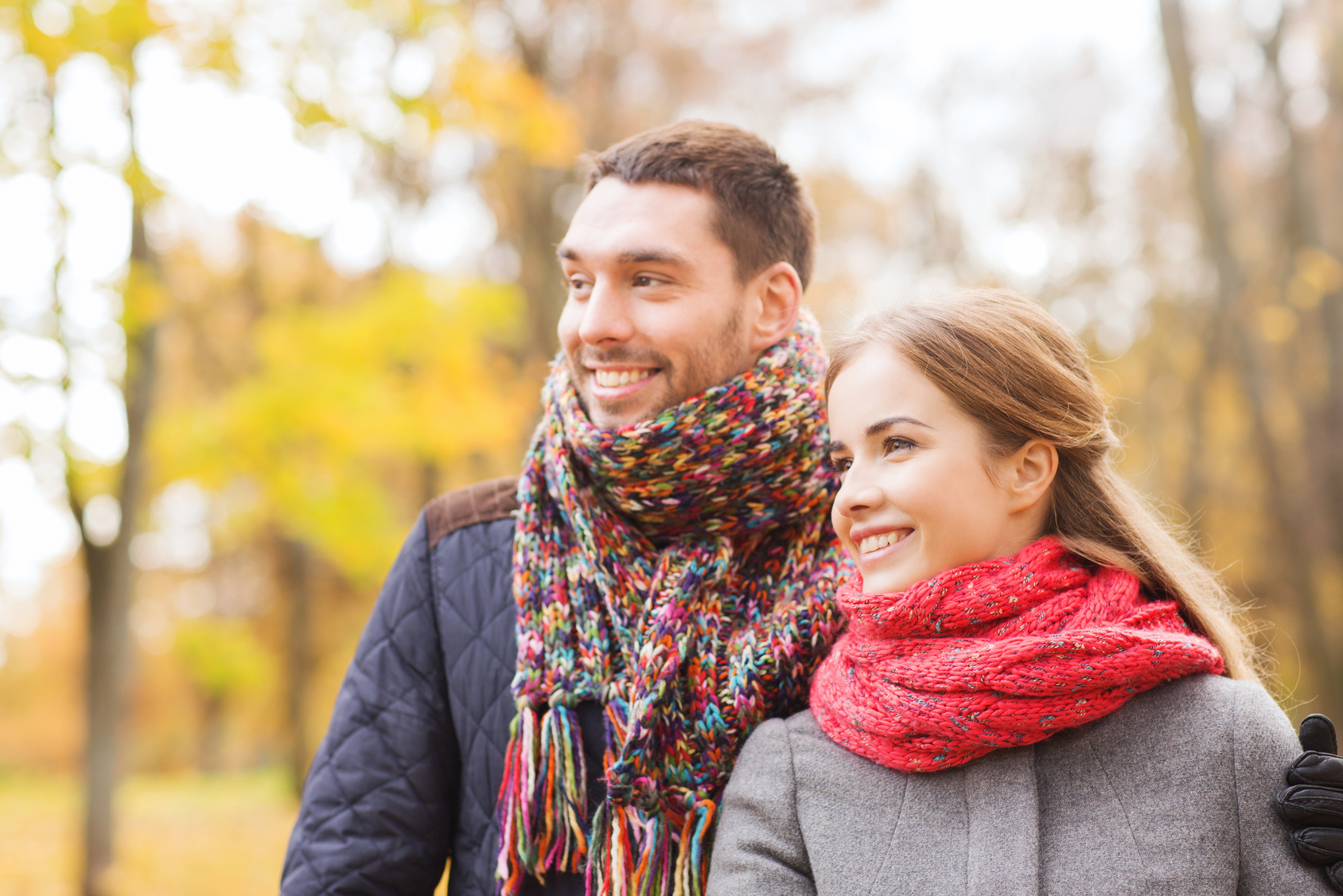 smiling couple hugging on bridge in autumn park