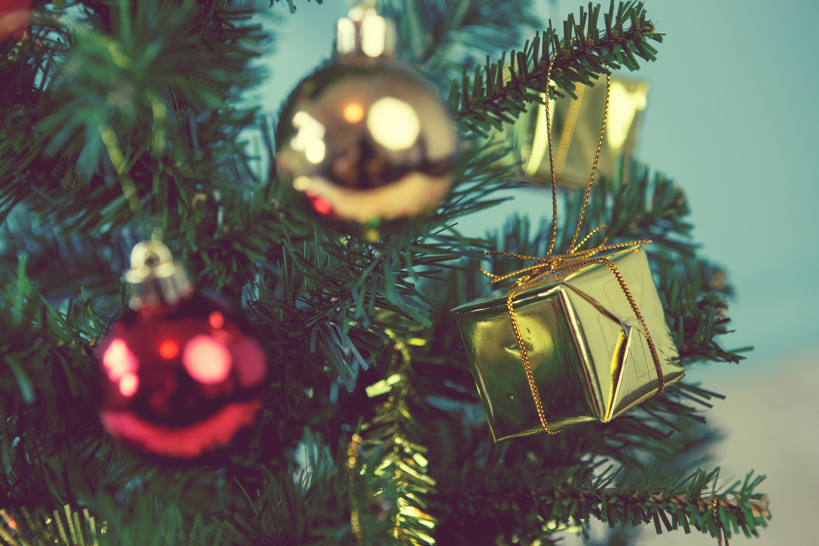 Christmas tree with gifts on green background on blurred, vintag