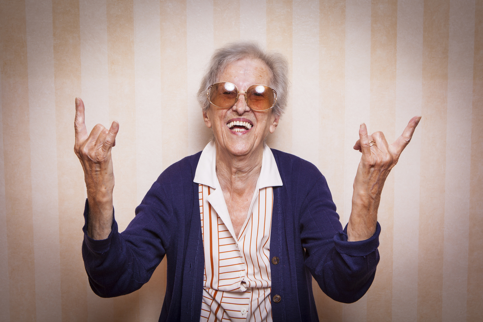 cool elder lady making rock on sign