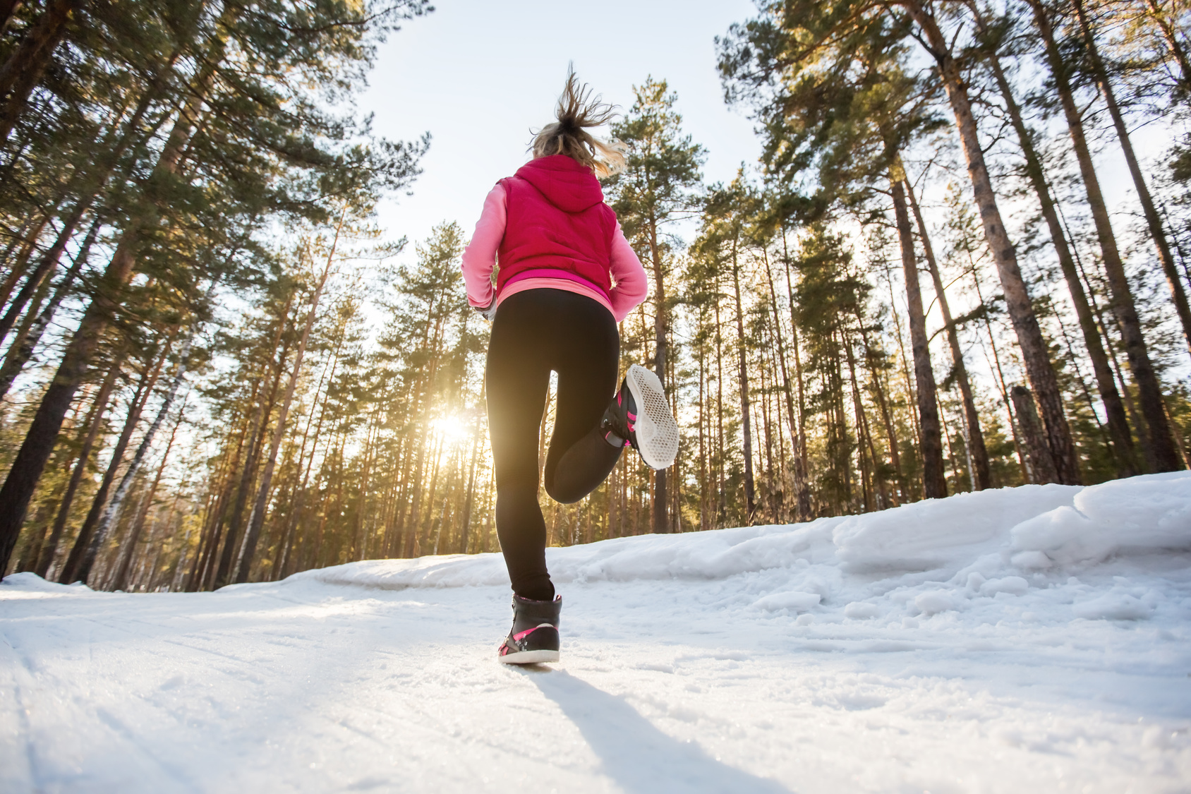 The girl running in winter Park by evening.