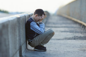 young homeless boy  crying on the bridge