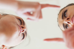 Low angle view of angry young females having an argument over white background