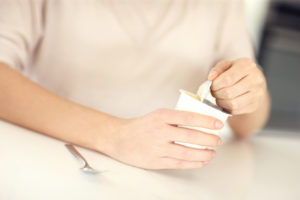 Woman opening yogurt