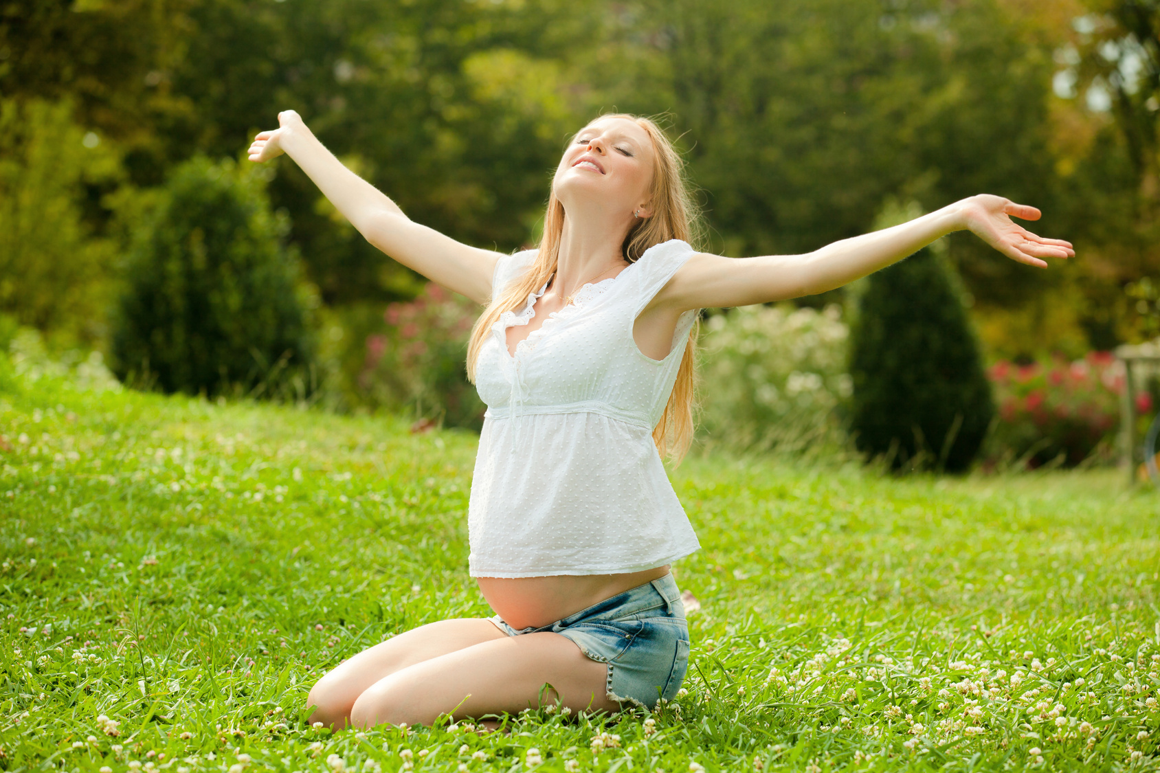 happy pregnant woman in summer meadow