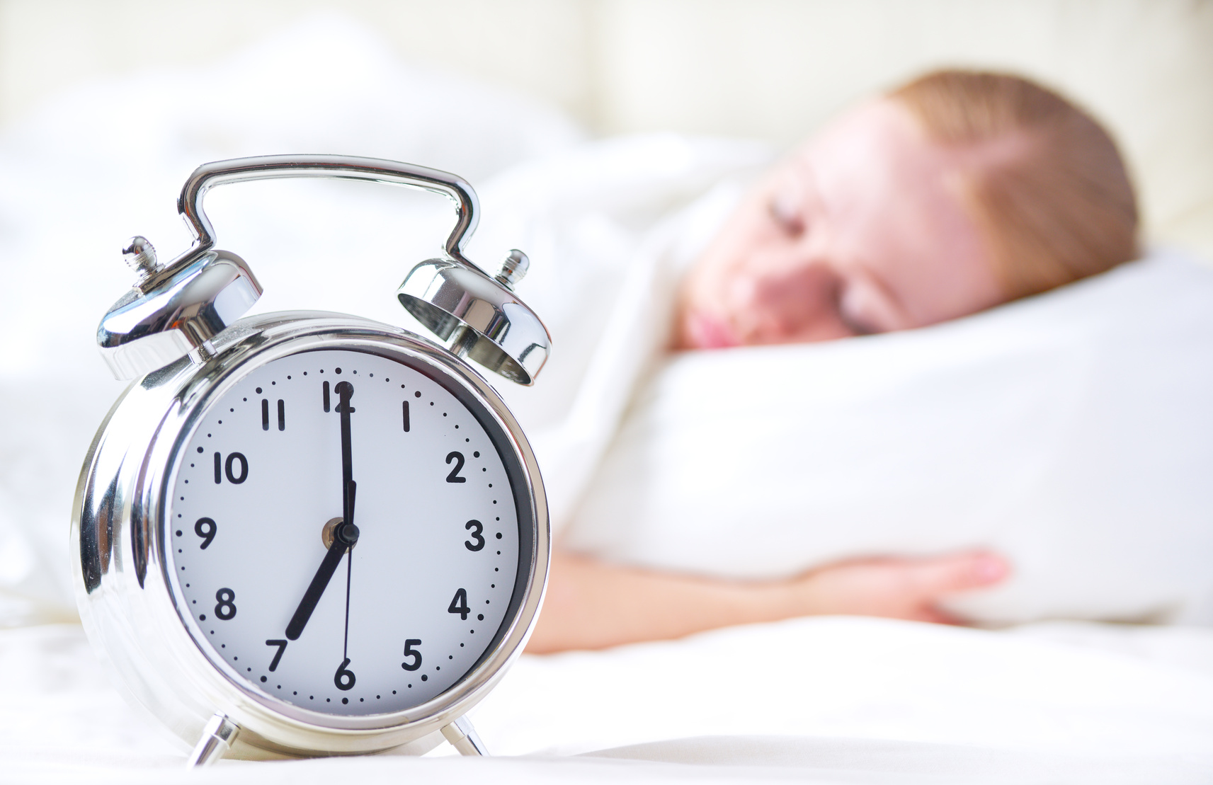 alarm clock and sleeping young woman