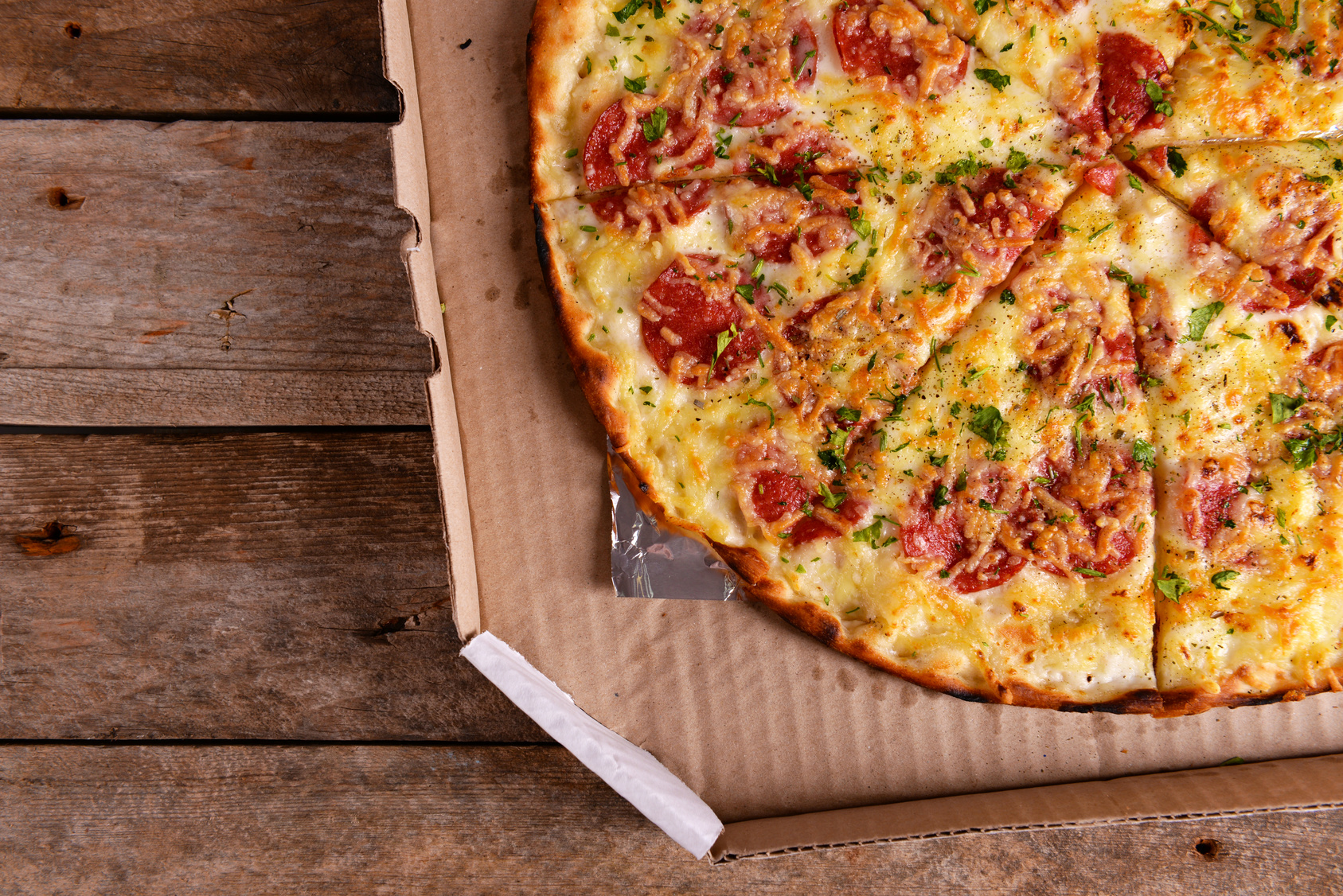 Tasty pizza in box on wooden background