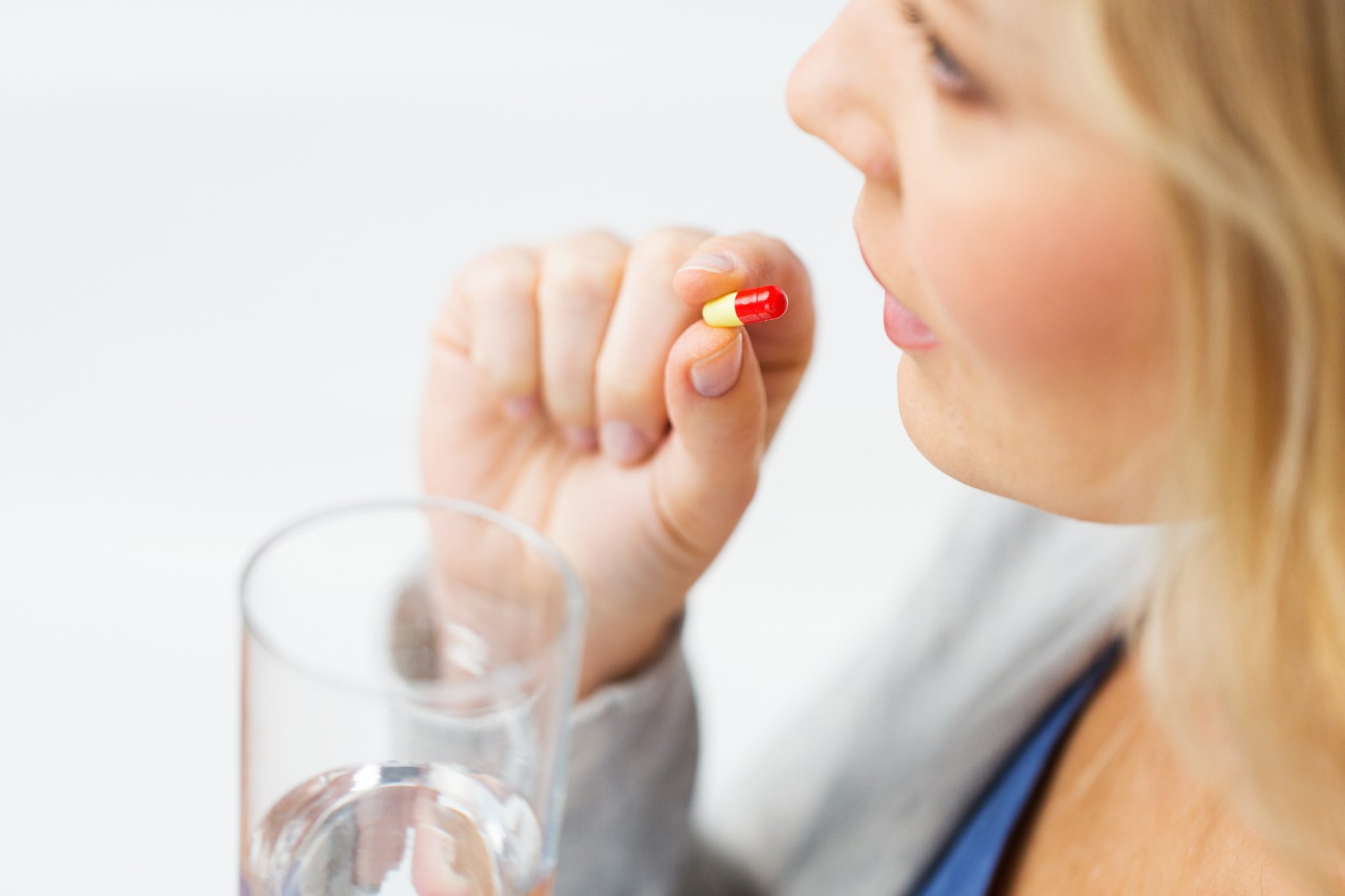close up of woman taking medicine in pill
