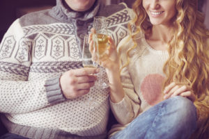 Beautiful young couple celebrating christmas drinking champagne