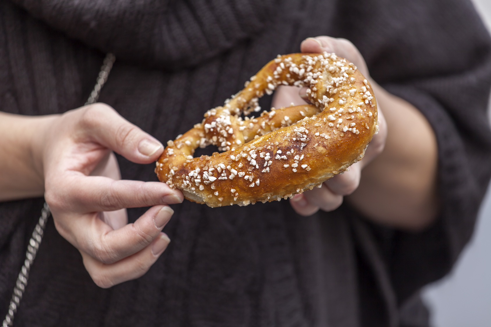 The woman holds an appetizing roll in hand