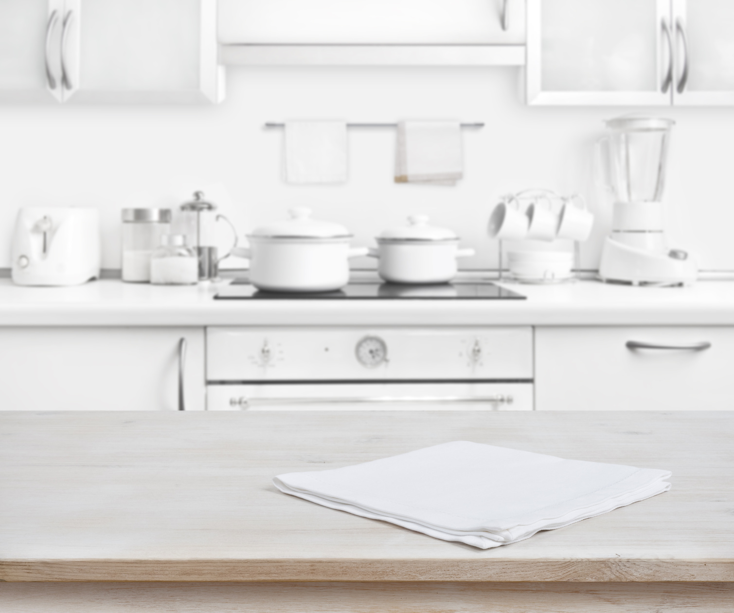 Wooden table with towel on blurred white modern kitchen background