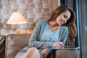 Cute young woman using tablet and smiling
