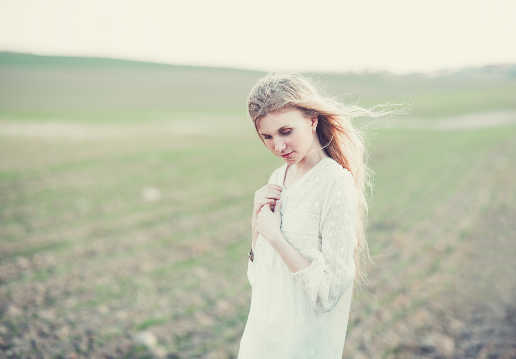 beautiful girl in dress walking in a field in spring