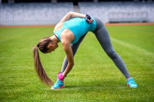 female runner stretching and relaxing muscles after workout
