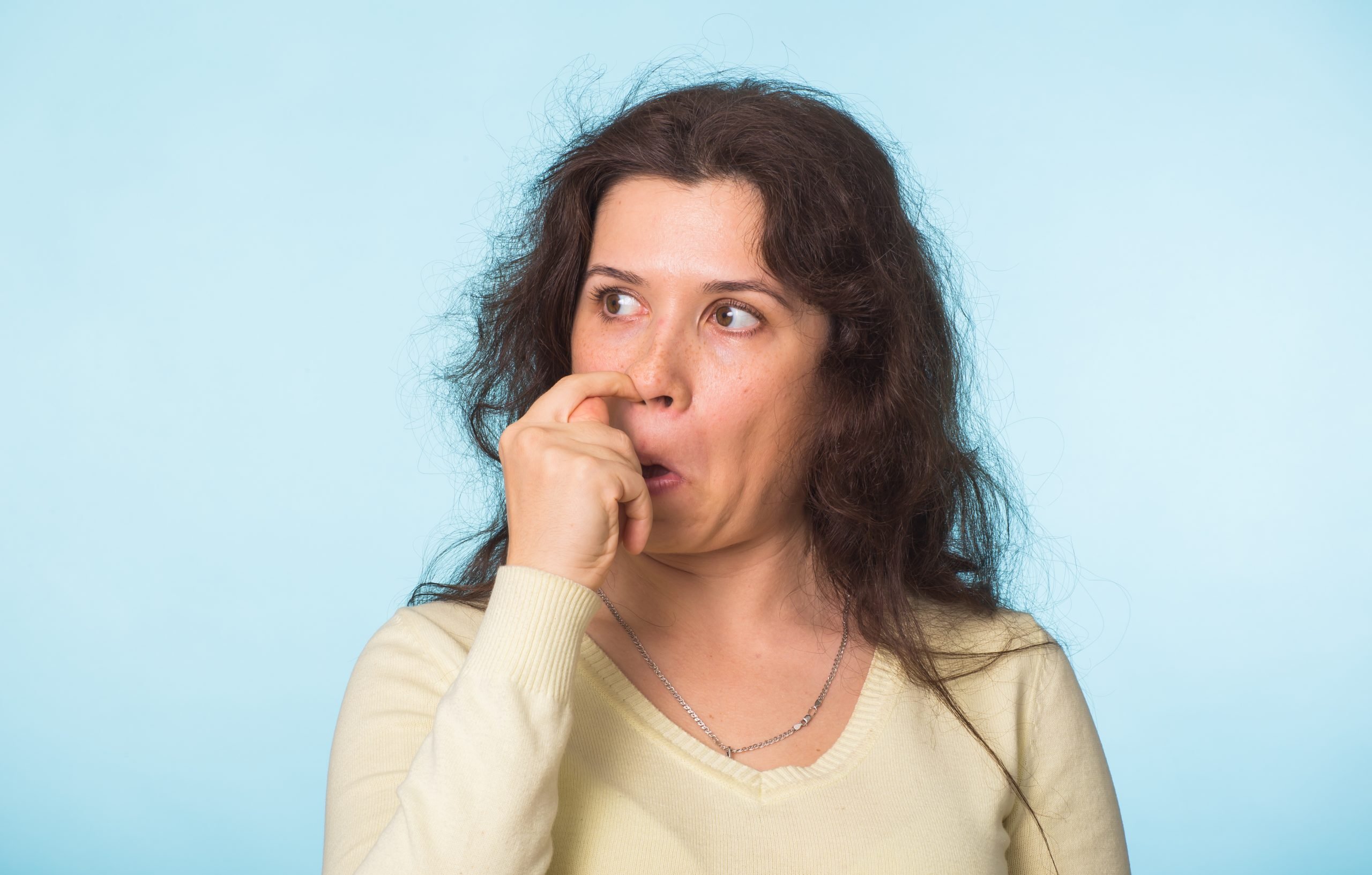 Woman picks his nose finger. Female climbs a finger in nose. Embarrassment