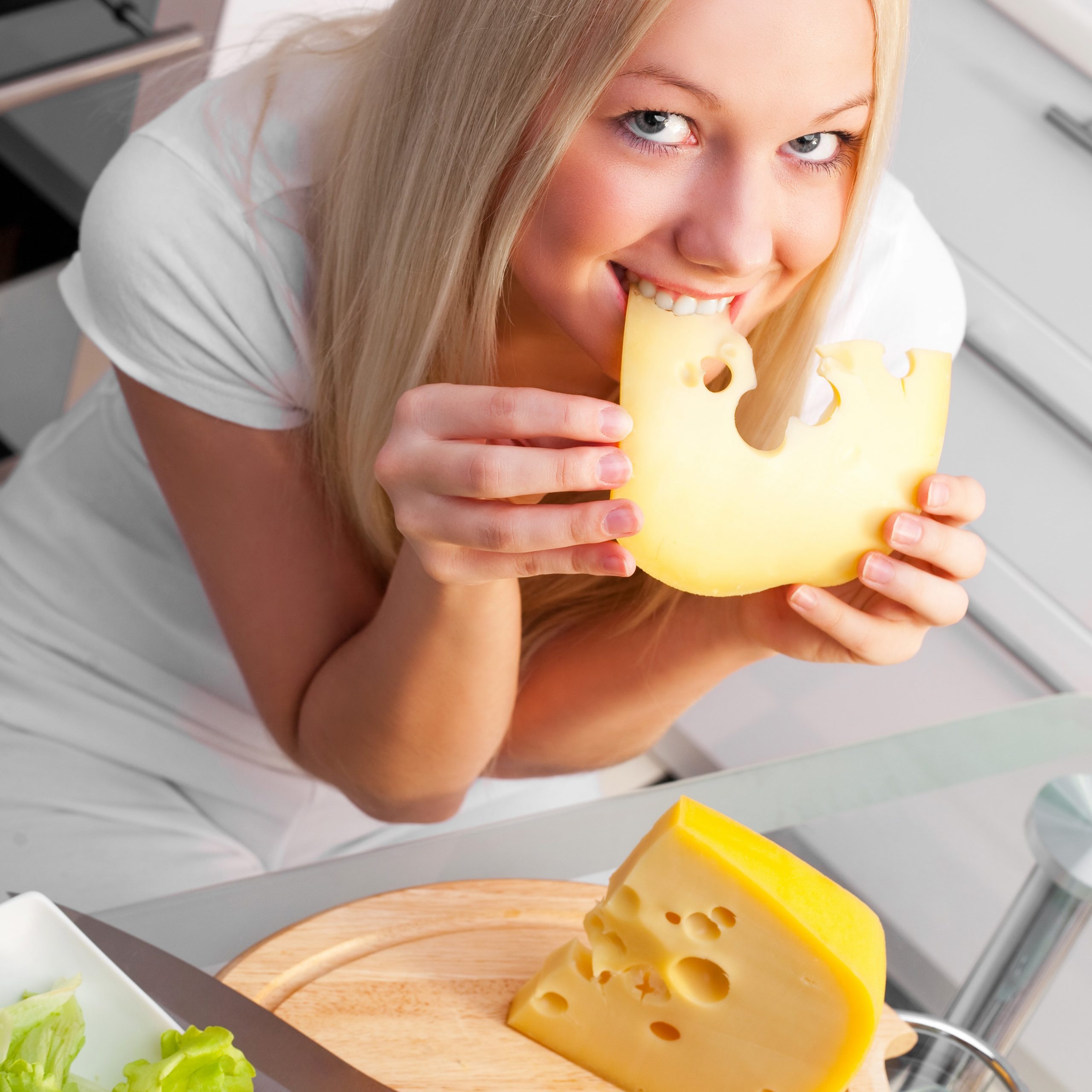 beautiful young woman eating cheese
