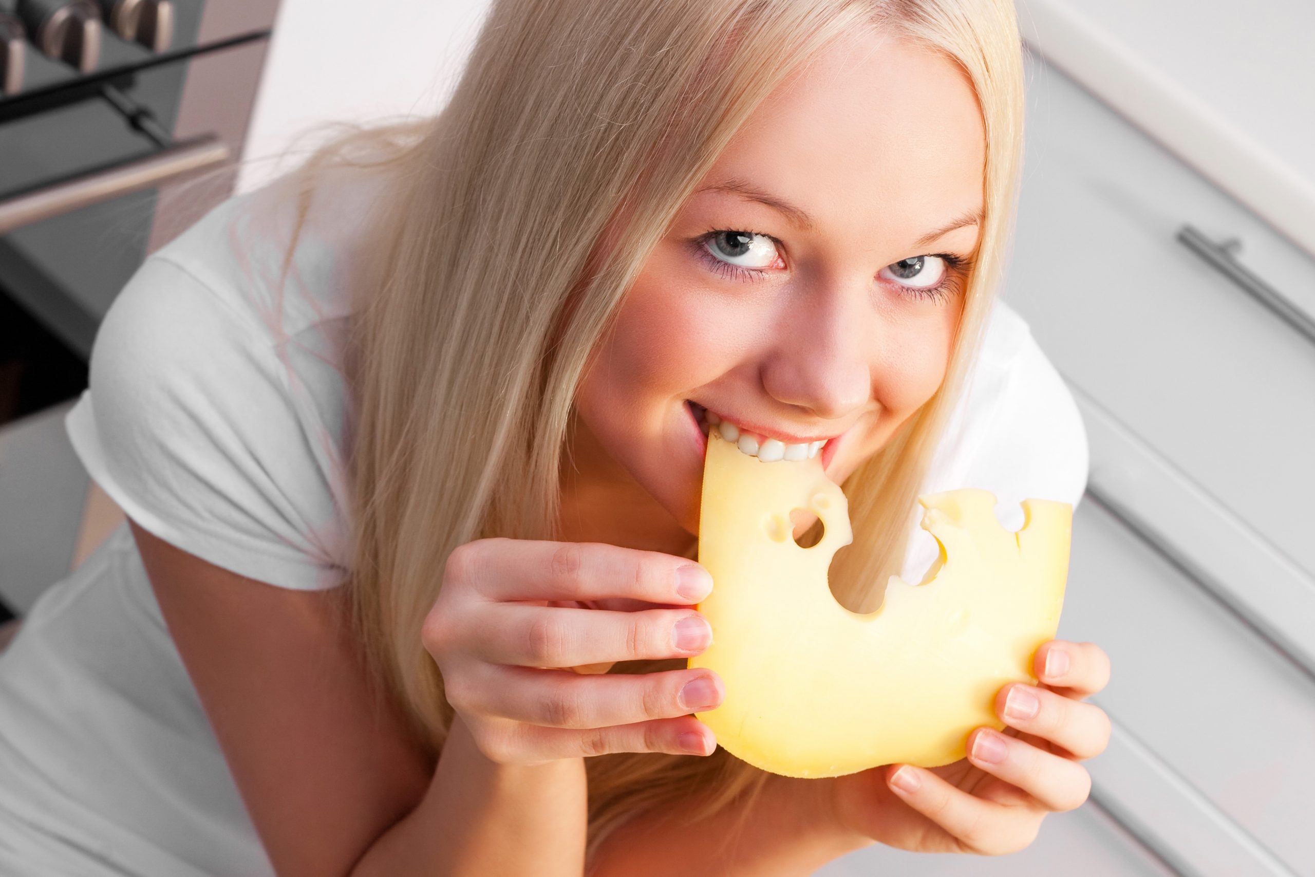 beautiful young woman eating cheese