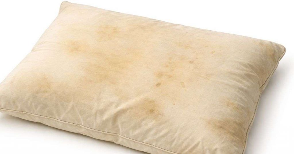 Kellertävä ja tahriintunut tyyny.